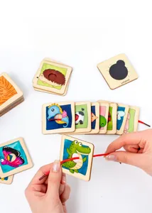 Primo piano di mani di bambino che infilano carte di animali in legno con un cordoncino rosso