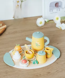 Dettaglio del set da tè in legno per bambini con teiera e dolci giocattolo su un vassoio