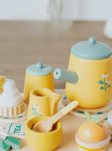 Dettaglio del set da tè in legno con teiera giallo limone e motivi a margherita