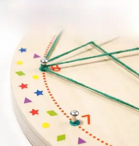 Close-up of wooden geoboard featuring metal pegs, green string, and geometric patterns