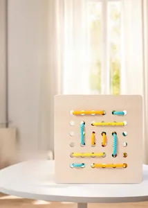 Dettaglio del gioco Montessori in legno con corde colorate per coordinazione occhio-mano