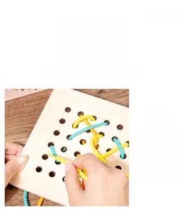 Dettaglio di mani che infilano corde in una tavola di legno Montessori per bambini