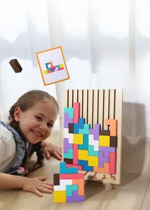 Girl playing with colorful wooden Tetris puzzle blocks on tray with guide cards