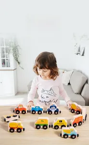 Close-up of child playing with magnetic wooden vehicle train toys on a table