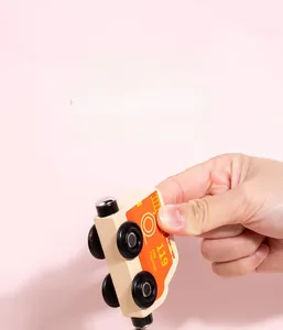 Detail showing hand magnetic assembly of a wooden fire truck toy with 119 printed on it
