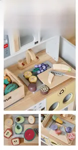 Détail de la cuisine en bois pour enfants avec fruits à couper et cuisinière magnétique