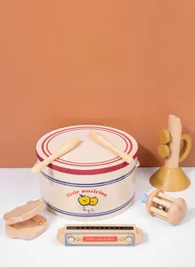 Macro shot of natural wood percussion instruments including a drum with little musician logo