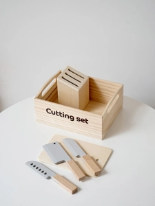 Détail de l'ensemble de découpe en bois avec couteaux jouets, planche et boîte