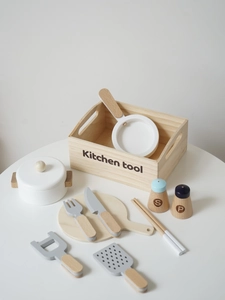 Détail d'un ensemble de 11 jouets de cuisine en bois avec ustensiles sur une table blanche