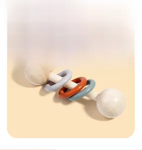 Detailed view of a wooden baby rattle with three colorful rings for sensory training