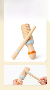 Detail of wooden agogo bell with mallet featuring natural wood grain and colorful rings