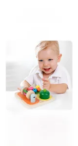 Detail showing colorful wooden beads and sensory rollers on the Montessori busy board