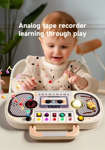 Toddler playing with wooden analog tape recorder busy board with buttons and lights
