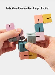 Close-up of hands twisting a multi-color wooden 3D puzzle cube with elastic bands