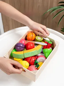 Kleinkindhände halten ein Holztablett voller bunter magnetischer Spielzeugfrüchte
