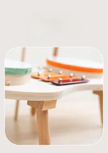Dettaglio del tavolo musicale in legno con mini tamburi e xilofono colorato