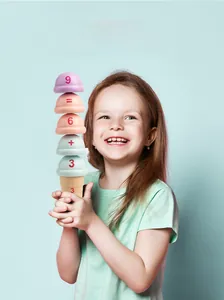 Smiling girl playing with stackable educational ice cream toy showing math numbers