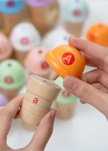 Close-up of hands pairing colorful wooden ice cream toy with uppercase and lowercase letters