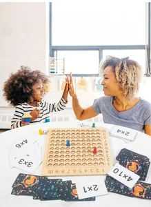 Close-up of wooden multiplication board game with practice cards and colorful pawns