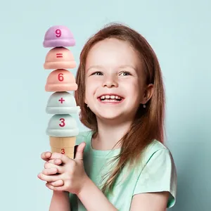 Toddler girl playing with colorful wooden ice cream stacking toy for math learning