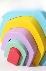 Detail of wooden rainbow stacker toy showing smooth water-based paint finish and grain