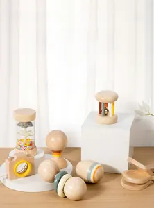 Detail of wooden rattle set featuring a natural wood camera and colorful beads on white podiums