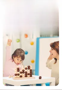 Family playing with a 3D wooden four-in-a-row game set on a bright wooden table