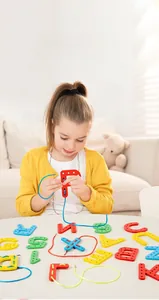 Close-up of a child threading colorful letter blocks to improve fine motor skills