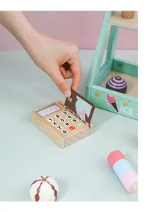 Interaction detail showing a wooden card reader and credit card for ice cream toy set