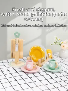 Detail of wooden tea set toys with water-based paint finish on a plaid tablecloth