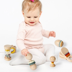 Educational wooden musical rattle set for infants with baby holding a natural sand shaker