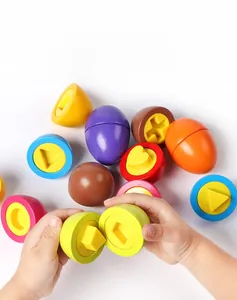 Toddler hands matching colorful geometric shapes inside educational plastic egg toys