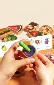 Detailed view of child's hand threading wooden blocks onto a green caterpillar string toy