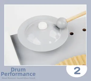 Détail d'un jouet musical en bois montrant une cymbale métallique et un petit maillet