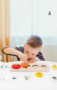 Bambino che esplora i cicli vitali con un puzzle educativo in legno e schede