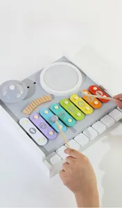 Détail d'un jouet musical en bois avec xylophone à 8 notes, touches de piano et tambours