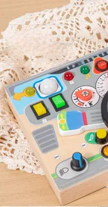 Detail of wooden activity board with realistic knobs, switches, and steering gear