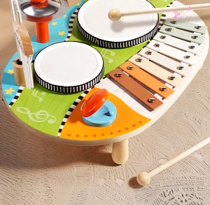 Detail of wooden musical activity table showing colorful xylophone and percussion drums
