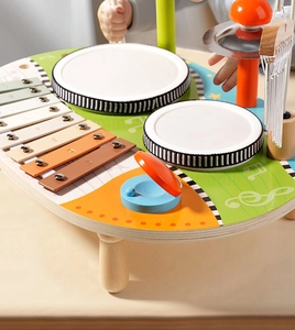 Close-up of children's hands playing on a multifunctional wooden musical toy table