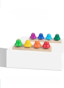 Close-up of 8-note metal hand bells with wooden base for children musical education