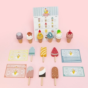 Wooden toy ice cream shop set with popsicles, cones and play money on pink background