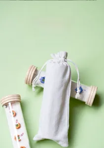 Detailed view of cylindrical wooden maze toys with a cotton drawstring storage bag