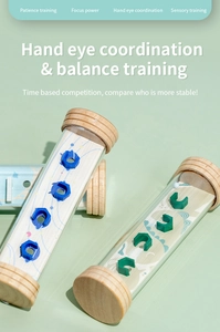 Detail of wooden balance puzzle tube showing internal ball maze and ocean graphics