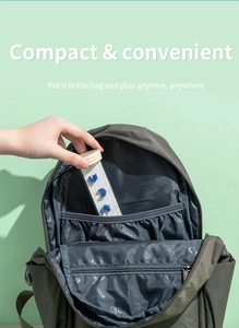 Portable wooden balance maze toy being placed into a multi-compartment backpack