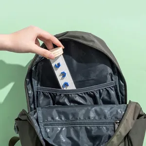Portable wooden balance ball maze toy being placed into a backpack compartment for travel