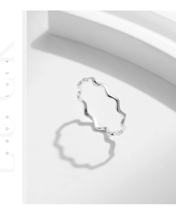 Makrodetail eines minimalistischen S925 Silber Wellenrings mit polierter Oberfläche