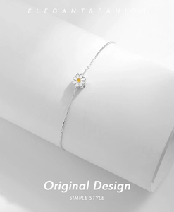 Detailed shot of S925 silver daisy bracelet with white enamel petals on a white pedestal