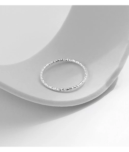 Macro view of slender S925 sterling silver ring featuring a sparkling diamond-cut texture