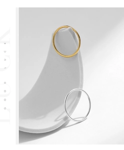 Minimalist stackable gold and silver bands displayed on white sculptural stone props