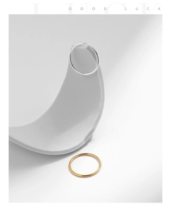 Artistic detail of gold and silver minimalist thin rings on modern grey curved stands